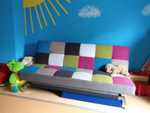 Farbiges Sofa vor hellblauer Wand