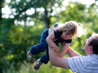 Vater wirft Tochter in die Luft beim Spielen